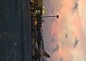 Sunset over a harbor with boats docked and a sky filled with scattered clouds