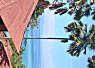 A tropical beach scene with palm trees, sandy shore, and calm sea under a bright blue sky with a few clouds