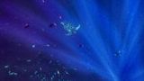 Underwater scene with a sea turtle swimming among a school of small colorful fish illuminated by rays of sunlight filtering through the deep blue water