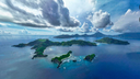 aerial view of a group of volcanic islands with lush green hills surrounded by deep blue ocean under a partly cloudy sky