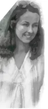 Smiling woman with wavy hair wearing sunglasses on her head and a light-colored blouse